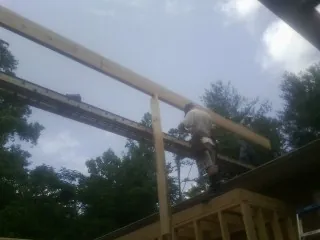 Carpenter setting a ridge beam over a new addition frame — Ice Dam Removal by Roofing Brothers in Brodheadsville