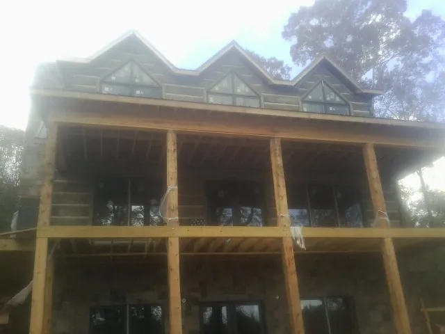 Dormers and porch framing on a large log home under construction — Roof Coating work by our crew in Brodheadsville
