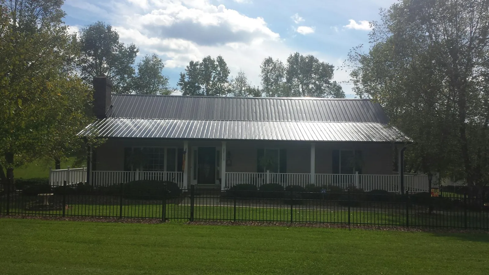 Gray metal roof on a brick ranch with a full width front porch — Gutter Guard Installation work by our crew in Brodheadsville