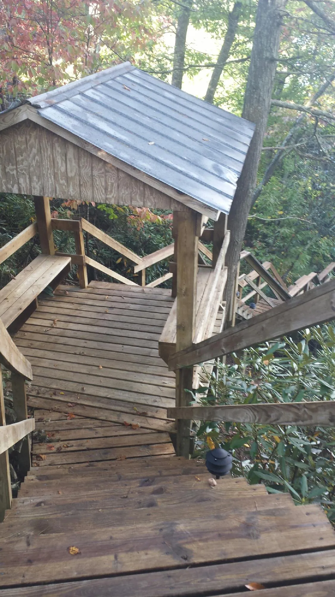 Metal roofed shelter over wooden steps on a wooded walkway — Skylight Repair & Installation work by our crew in Brodheadsville